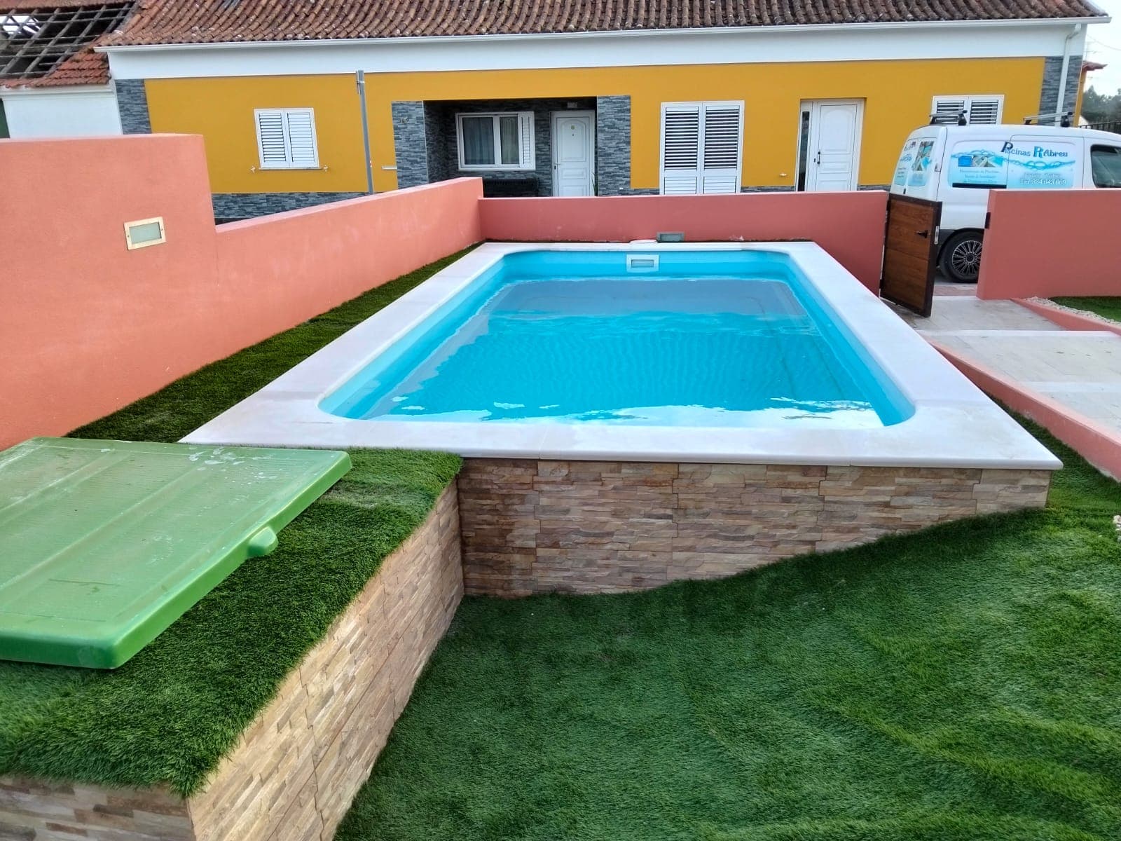 Piscina finalizada com relva e acabamento em pedra